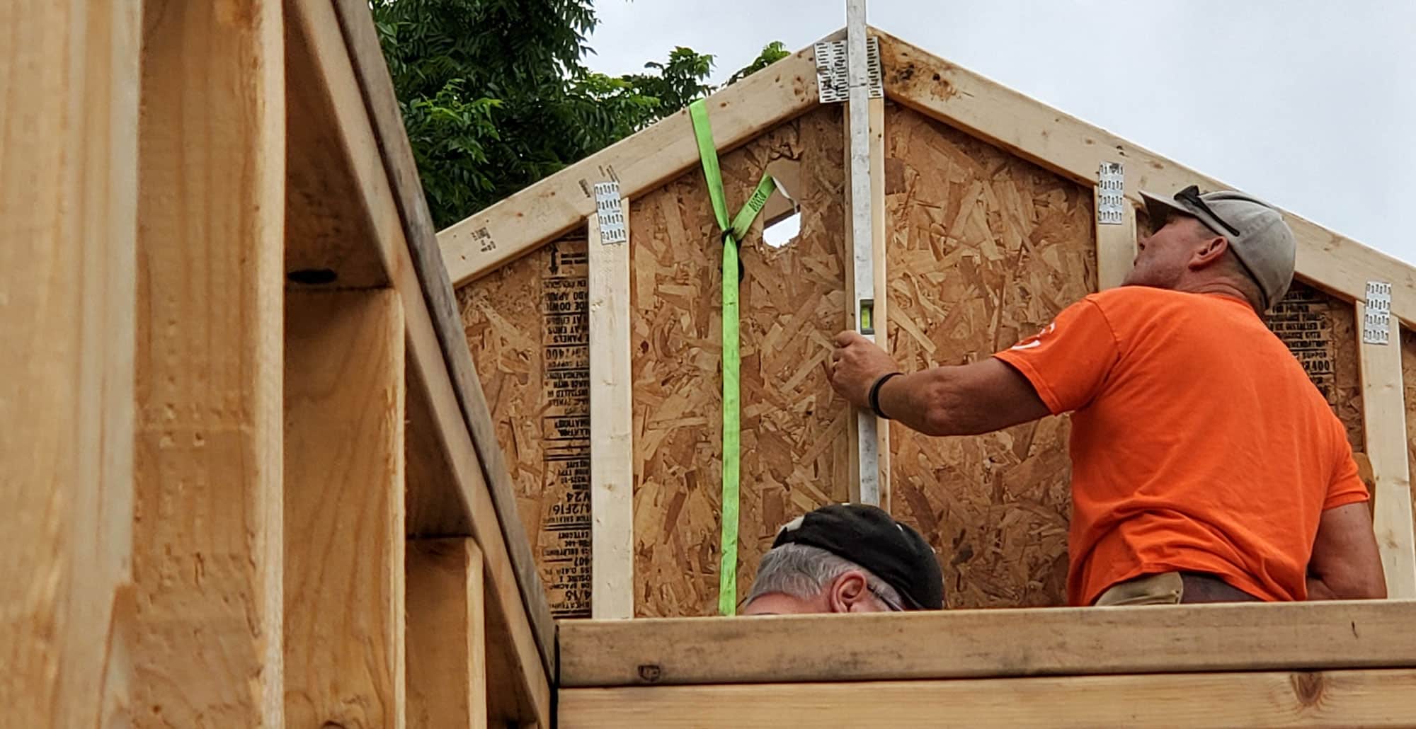 Two men working on the roof framing of a Habitat house