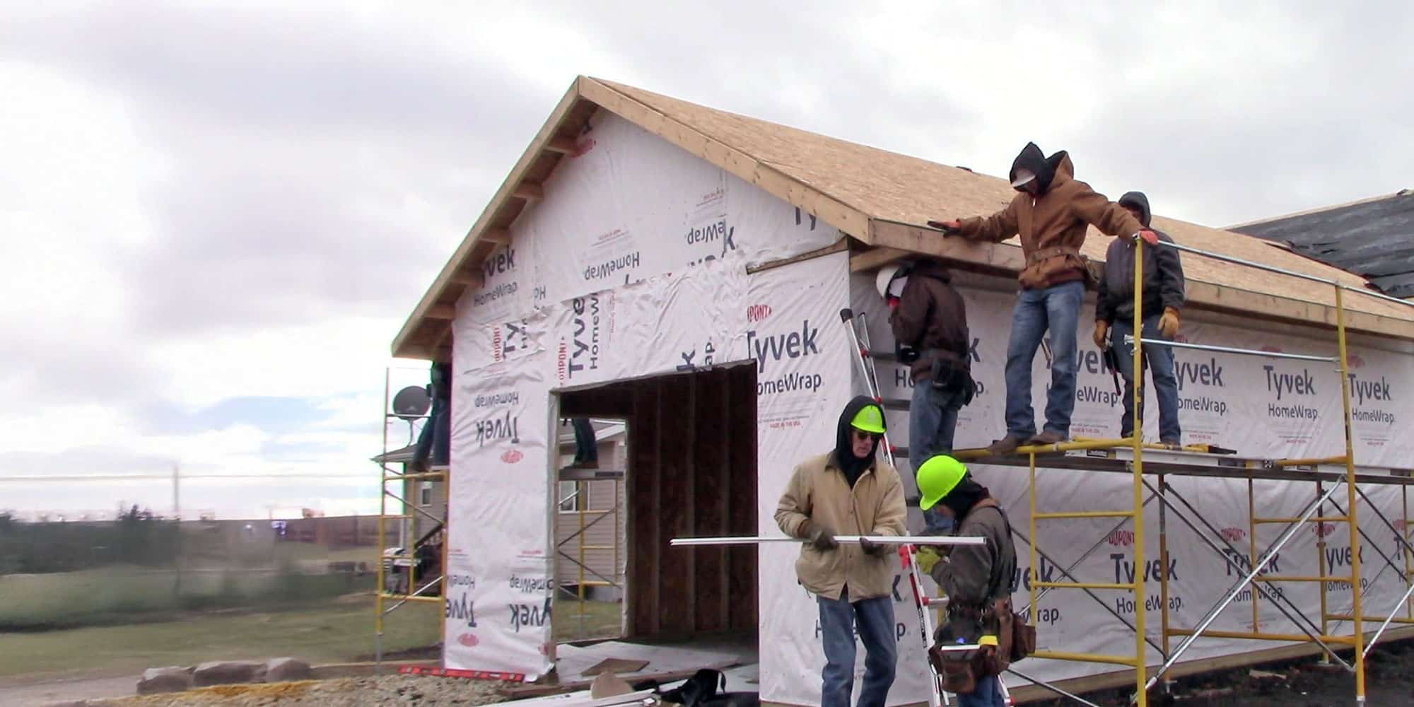 Four men framing a garage area