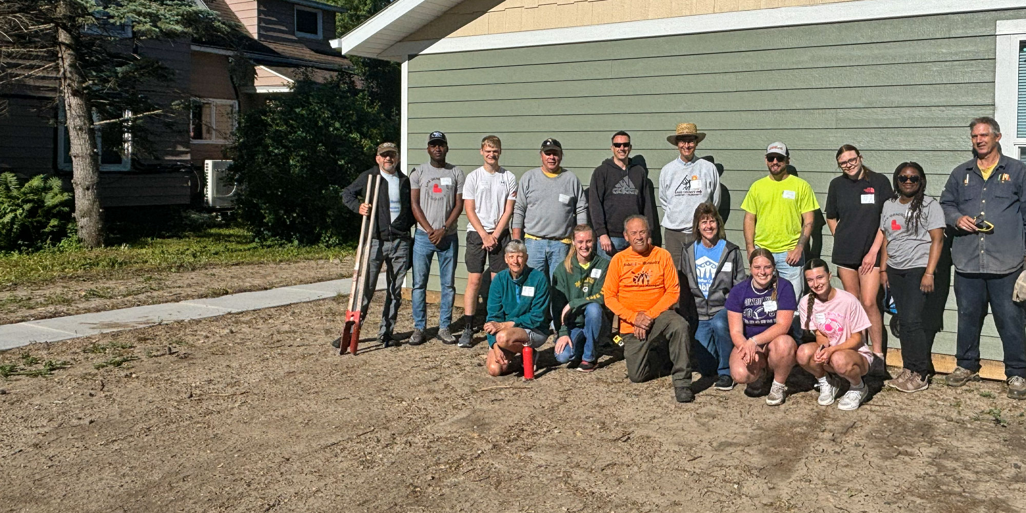 group of 16 volunteers at a home revitalization project