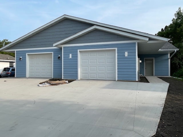Blue, single garage twin home with concrete driveway