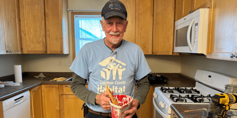 Volunteer Darwin holding a paint can in one of our Habitat builds.