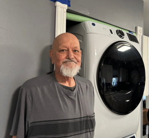 Michael, homeowner, in front of his new stackable washing machine.
