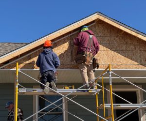 Two Habitat volunteers working on the facade of a new home build