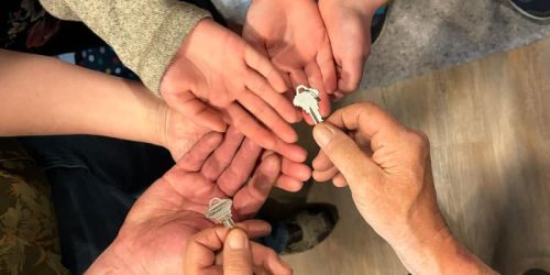 6 hands receiving a house key together