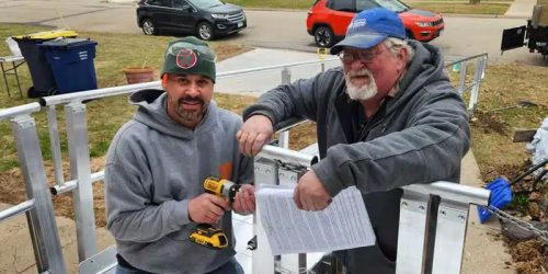 Two male Habitat volunteers working on a ramp as a home revitalization project