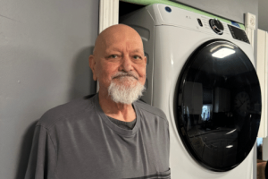 Michael, homeowner, in front of his new stackable washing machine.